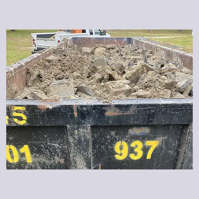 Dump trailer filled with debris and concrete from a mobile home removed by Next Day Demolition.